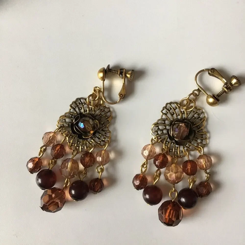 Darling ornate clip on earrings with beaded accents in amber/garnet tones
